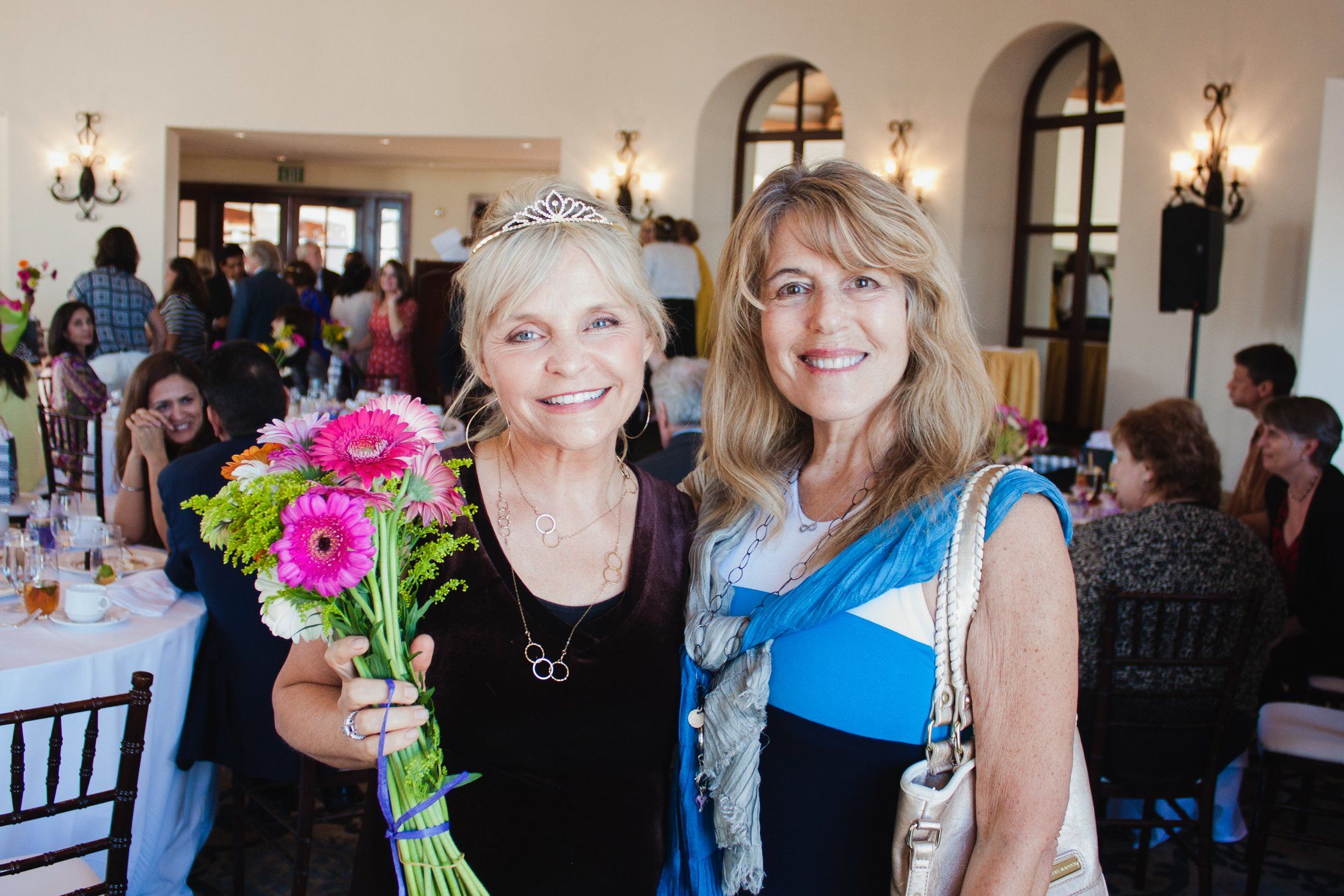 Two guests holding flowers at a celebration event in Sydney